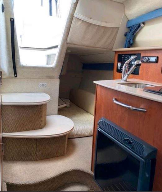 Bayliner 245 Ciera Sunbridge Innenaufnahme der zweiten Schlafkabine unter Deck mit Küche - zu kaufen über Mosel Yachting