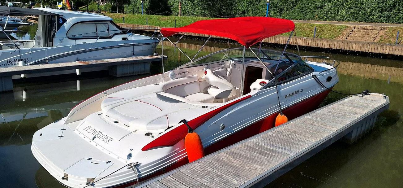 Rinker Captiva 246 mit rotem Bimini passend zu den roten Farbstreifen des Bootes