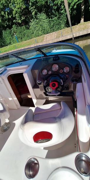 Rinker Captiva 246 mit rotem Bimini passend zu den roten Farbstreifen des Bootes, Steuerstand