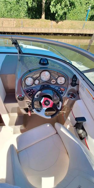 Rinker Captiva 246 mit rotem Bimini passend zu den roten Farbstreifen des Bootes, Steuerstand