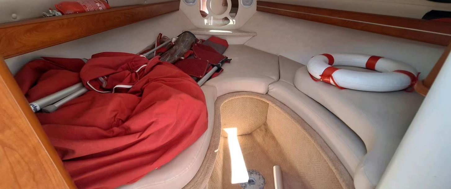 Rinker Captiva 246 mit rotem Bimini passend zu den roten Farbstreifen des Bootes, Blick in die Kabine