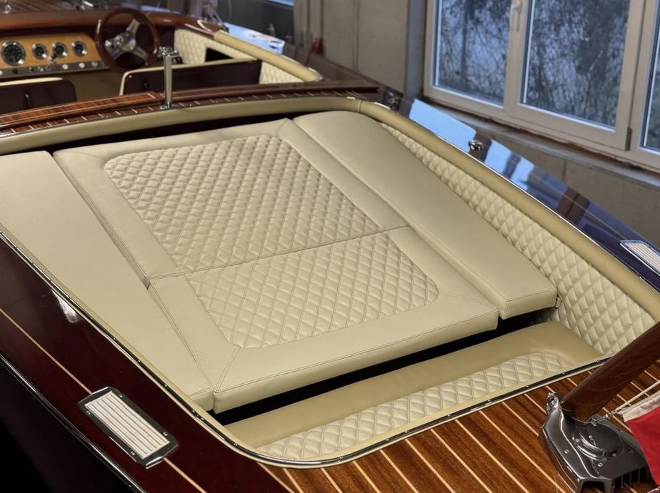 Gebrauchter Sportboot-Klassiker der Firma Boesch -Blick auf die Sitzgelegenheit im Heck zur Liegefläche ausgeklappt
