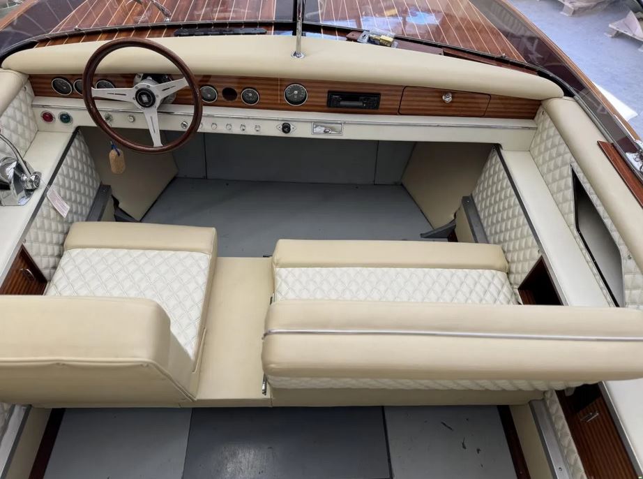 Aufwendig restaurierte Pedrazzini Capri Super Deluxe bei Mosel Yachting - Blick von oben hinten auf den Steuersitz mit Lenkrad sowie der Sitzbank daneben.