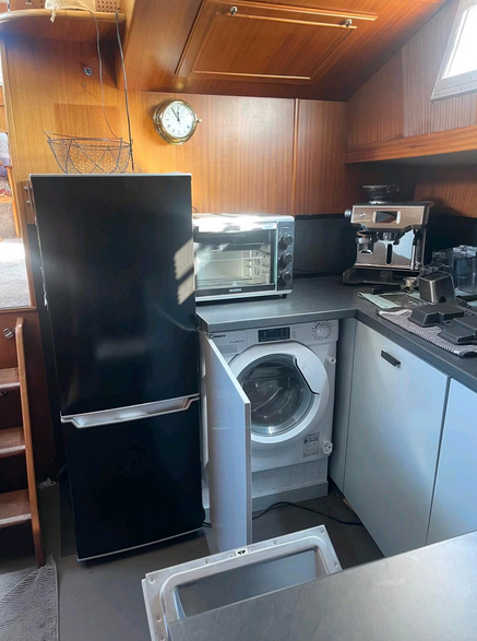 Drettmann Motoryacht bei Mosel Yachting - Blick in die Küche mit der Waschmaschinen-Trockner-Kombination neben der Kühl-Gefrierkombination.